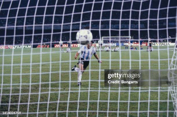 Argentine professional football player Diego Armando Maradona rejoices after scoring a penalty during the semi-finals match against Italy at the 1990...