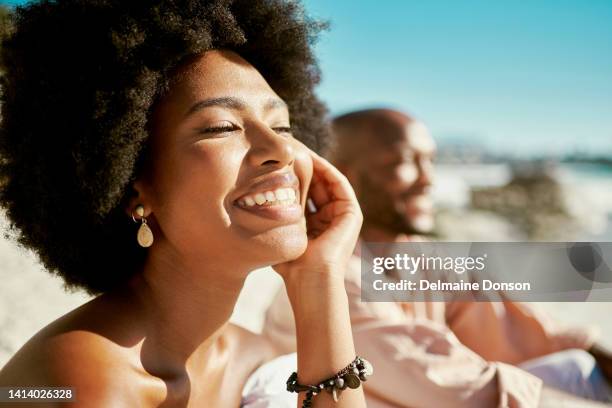 beauty, skincare and face of a beautiful woman glowing under the natural sunlight at the beach. stunning afro girl smiling looking confident and happy with her soft, shining and flawless skin outdoor - male model casual stockfoto's en -beelden