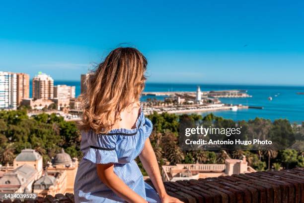 woman contemplating the city of malaga from a lookout point - malaga photos et images de collection