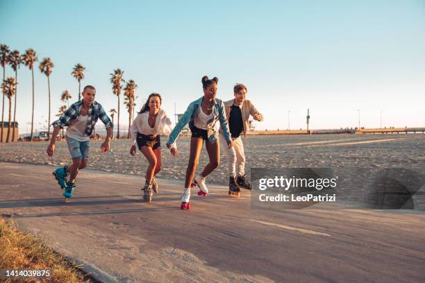 friends roller skating by the beach in california - venice beach stock pictures, royalty-free photos & images
