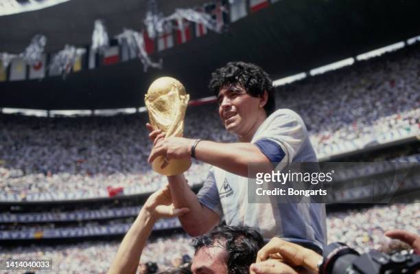 Argentine professional football player Diego Armando Maradona holds the World Cup trophy after Argentina defeated West Germany 3-2 during the 1986...