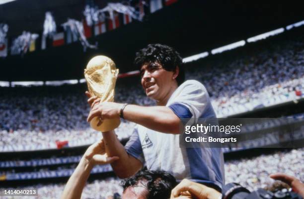 Argentine professional football player Diego Armando Maradona holds the World Cup trophy after Argentina defeated West Germany 3-2 during the 1986...