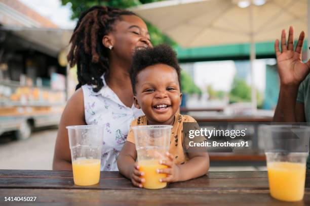happy family enjoying themselves outdoors - orange juice stock pictures, royalty-free photos & images