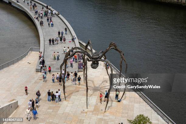 museo guggenheim de bilbao y la escultura de bronce de 11 metros de altura de una araña gigante llamada "maman" de louise bourgeois - frank gehry fotografías e imágenes de stock