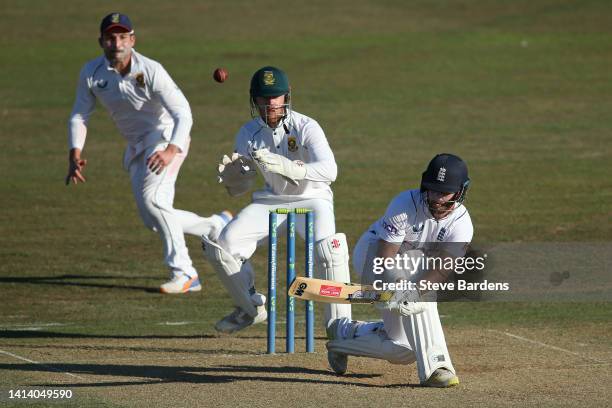 Ben Duckett of England Lions plays a sweep shot as Kyle Verreynne of South Africa looks on during day two of the tour match between England Lions and...