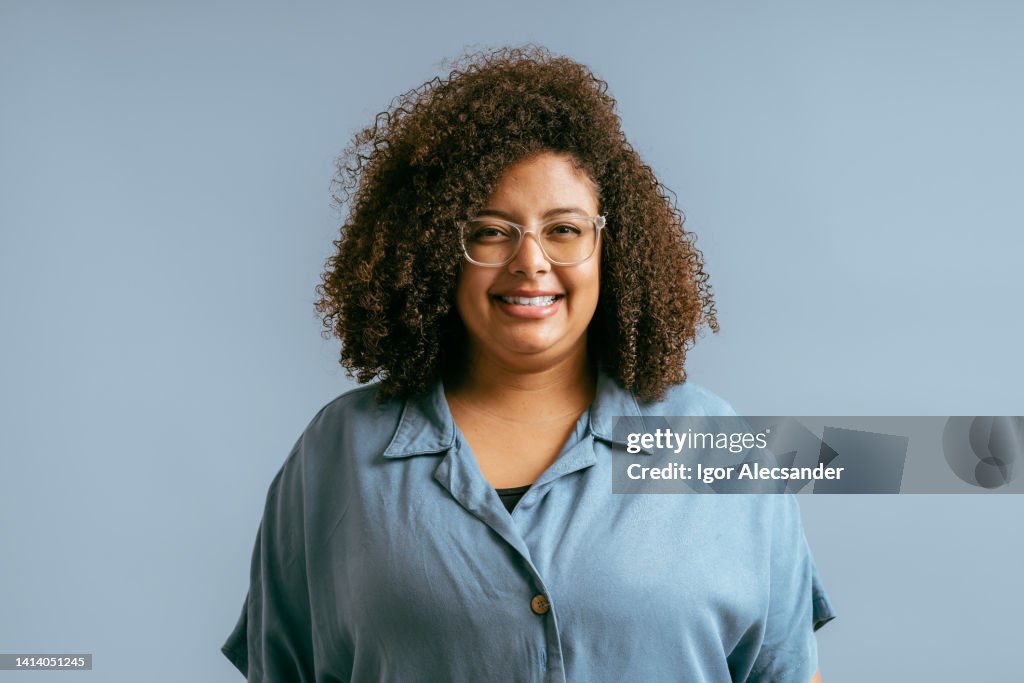 Portrait of young woman with curly hair in studio