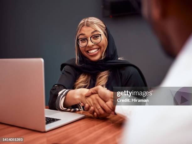 interview handshake between muslim hr manager and employee, greeting, welcome and thank you hand gesture at hiring meeting. female hijab human resources worker congratulating man on new job promotion - the honourable stock pictures, royalty-free photos & images