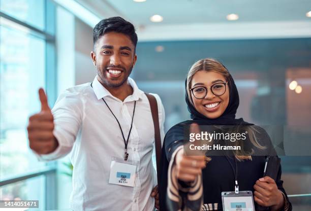 success, happy and young indian students at a college conference excited that their interview was successful. male and female journalist smiling and holding thumbs up gesture showing sign of approval - journalism student stock pictures, royalty-free photos & images