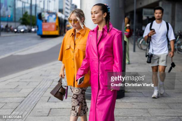 Guests seen wearing yellow, pink coat outside Remain during Copenhagen Fashion Week Spring/Summer 2023 on August 09, 2022 in Copenhagen, Denmark.
