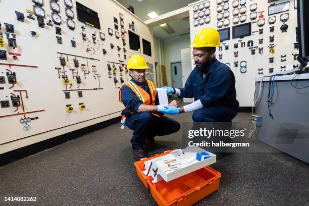 power plant operator receiving first aid after minor accident - safety kit imagens e fotografias de stock