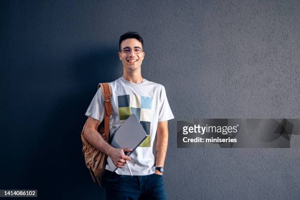 porträt eines gutaussehenden männlichen studenten mit einem laptop - male student wearing glasses with friends stock-fotos und bilder
