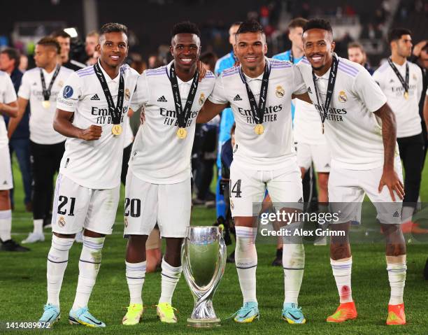 Rodrygo, Vinicius Junior, Casemiro and Eder Militao of Real Madrid pose for a photograph with the UEFA Super Cup trophy after the final whistle of...