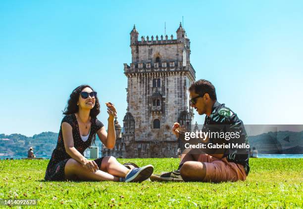 friends sitting on grass eating a pastel de nata - pastel de nata stock pictures, royalty-free photos & images