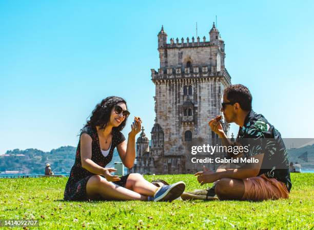 friends sitting on grass eating a pastel de nata - pastel de nata stock pictures, royalty-free photos & images