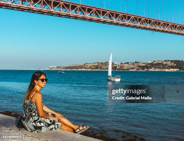 portrait of woman sitting by tagus river - sunset freinds city fotografías e imágenes de stock