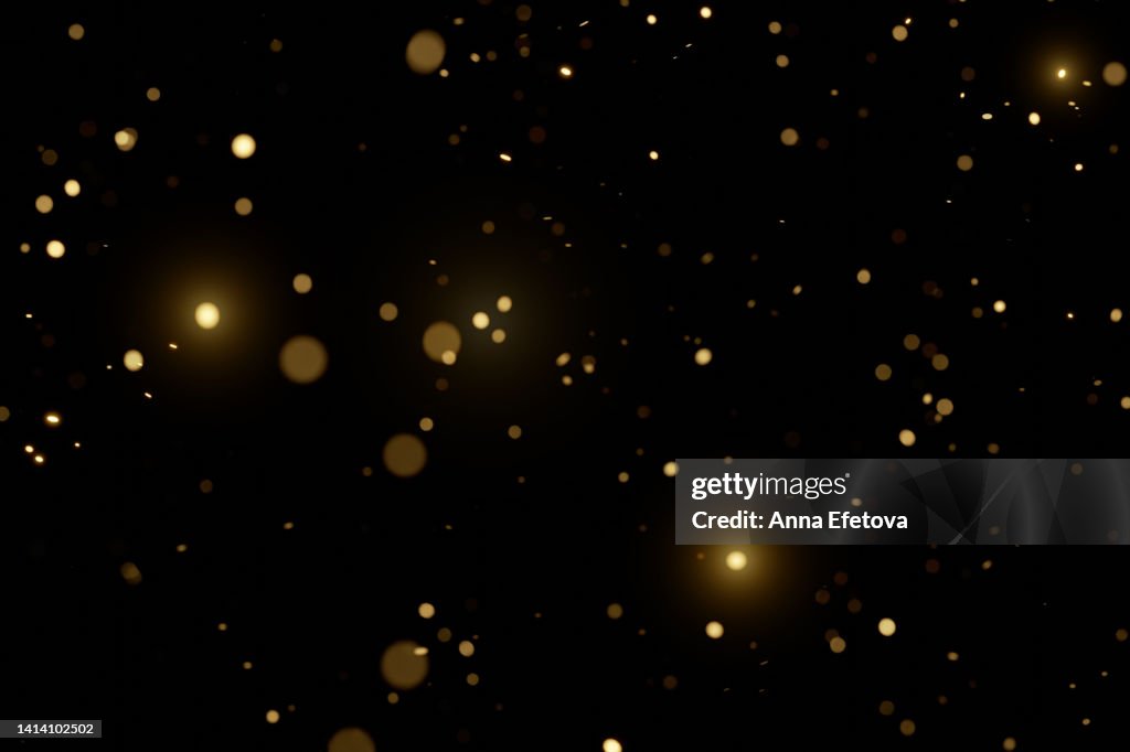 Blurred golden particles on black background. Holiday background. Festive colorful backdrop for your design. Merry Christmas and Happy New Year