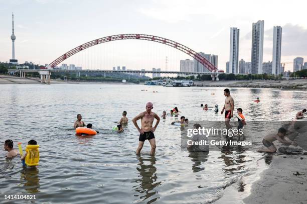 People swim in the intersection of the Han and Yangtze rivers during a heat wave on August 10, 2022 in Wuhan, Hubei Province, China. According to...