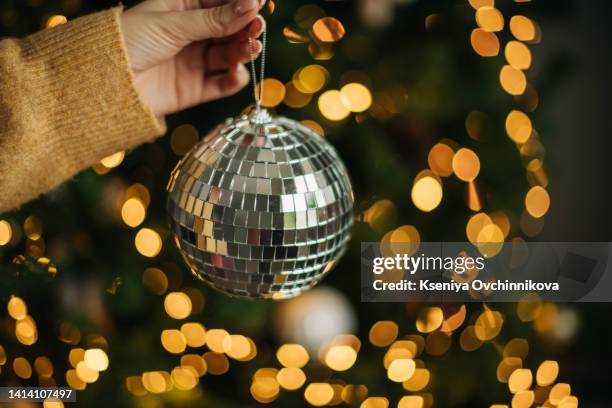 hand holding disco ball on string isolated on white background. - vintage hand mirror stock pictures, royalty-free photos & images