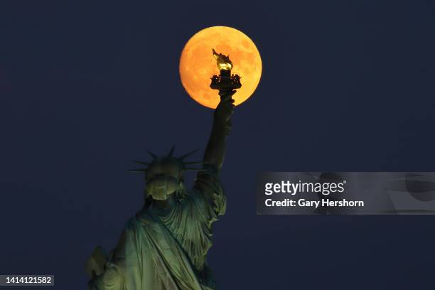 Percent illuminated waxing gibbous Sturgeon Moon rises above the Statue of Liberty in New York City on August 10 as seen from Jersey City, New Jersey.