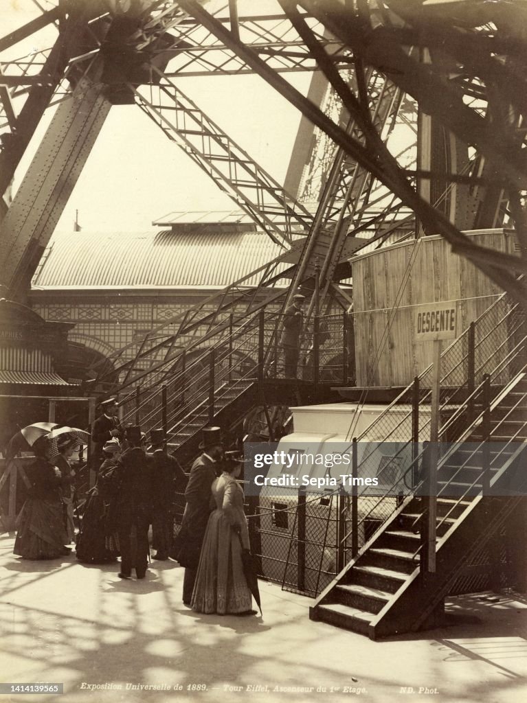 View of the base of the Eiffel Tower at the time of the Exposition Universelle of 1889, Exposition Universelle de 1889 - Tour Eiffel, ascenseur du 1er etage (title on object), Neurdein Frères (mentioned on object), publisher: Jules Hautecoeur (mentioned o