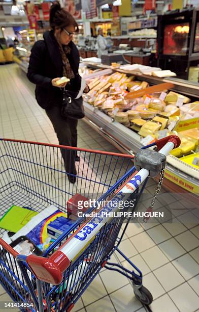 Photo prise le 15 mars 2012 à Hazebrouck, d'un chariot de super marché de l'enseigne Carrefour alors qu'une cliente choisi du fromage dans un...