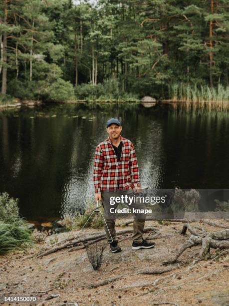 man out in nature by a lake fishing with rod - lake shore stock pictures, royalty-free photos & images