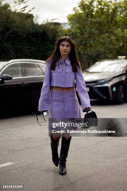 Guest wearing leather purple Dorothee Shumacher skirt and top with long brown cowboy shoes posing outside Rabens Saloner show during Copenhagen...