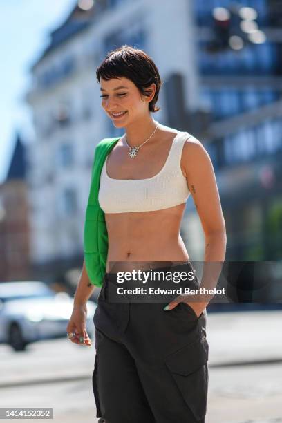 Alyssa Coscarelli wears a silver chain pendant necklace, a neon green puffy quilted fabric shoulder bag, a white ribbed wool / square-neck / cropped...