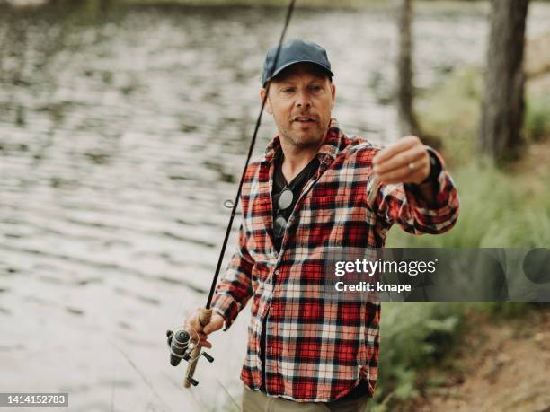 man out in nature by a lake fishing with rod - coarse fishing stock pictures, royalty-free photos & images