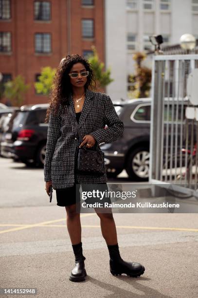 Guest wearing black shorts, black and white blazer, Dior bag and black bootsposing outside Gestuz show during Copenhagen Fashion Week Spring/Summer...