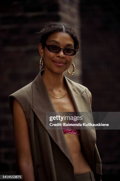 Sara Flaaen Lucius wearing brown summer suit and pink / red bra, pink open high heel sandals and brown Louis Vuitton mini bag and big Moschino...