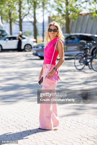 Guest is seen wearing pink Loewe bag, denim jeans, backless top outside Samsøe Samsøe during Copenhagen Fashion Week Spring/Summer 2023 on August 10,...