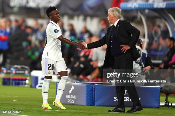 Vinicius Junior of Real Madrid shakes hands with coach Carlo Ancelotti as he leaves the field after being substituted during the Real Madrid CF v...