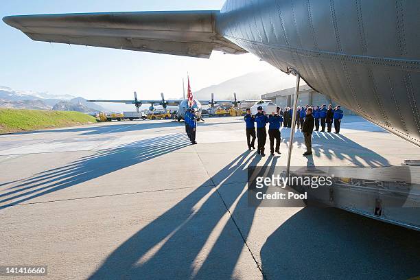Police officers carry the coffin of one of the 28 victims of Sierre's coach crash to load it into a Belgian military cargo aircraft at Sion airport...