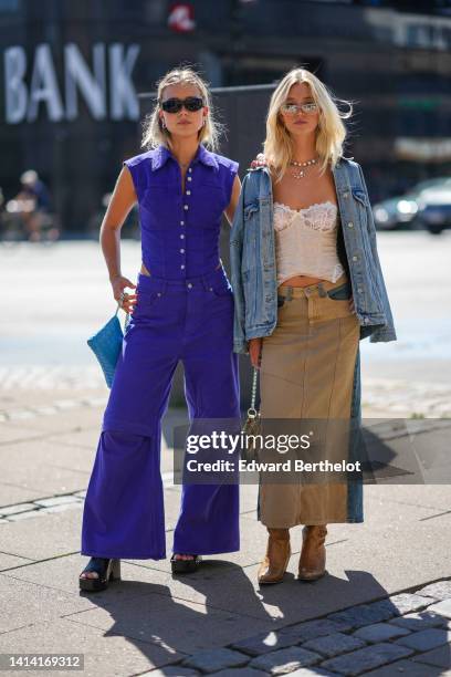 Guest wears black sunglasses, silver earrings, a neon purple denim sleeveless / cut-out waist / buttoned body, matching neon purple denim wide legs...