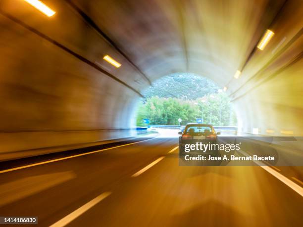 car point of view driving, car exiting a lighted tunnel on a highway. - light at the end of the tunnel car stock pictures, royalty-free photos & images