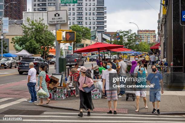 people with facemasks waiting to cross the street - queens - new york city stock pictures, royalty-free photos & images