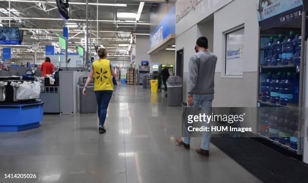 Gen Z man walking behind a worker inside a Cheyenne Wyoming Walmart