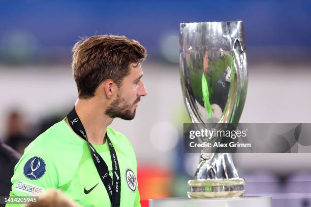 Kevin Trapp of Eintracht Frankfurt looks on as they walk past the UEFA Super Cup trophy after collecting their runners up medal after the final...