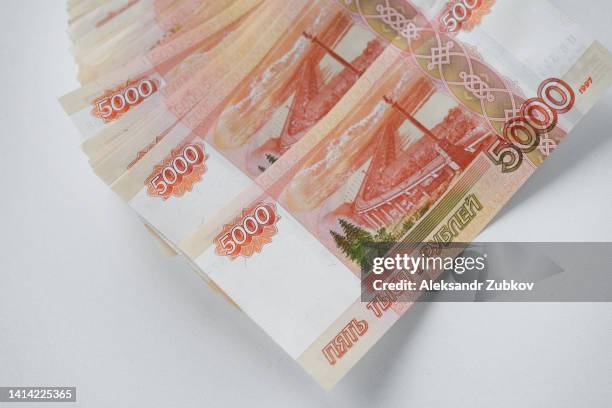 cash five thousand russian rubles in banknotes, on a white background. a pack of banknotes in close-up. pension savings, a bribe. the concept of receiving a salary, a loan and an income tax refund. payment for treatment, education. space for copying. - billete de rublo ruso fotografías e imágenes de stock