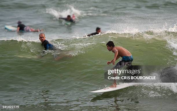 Surfers pack the break attempting to ride a wave at a local beach of Lima's ocean front on February 22, 2012. Every day early morning scores of...