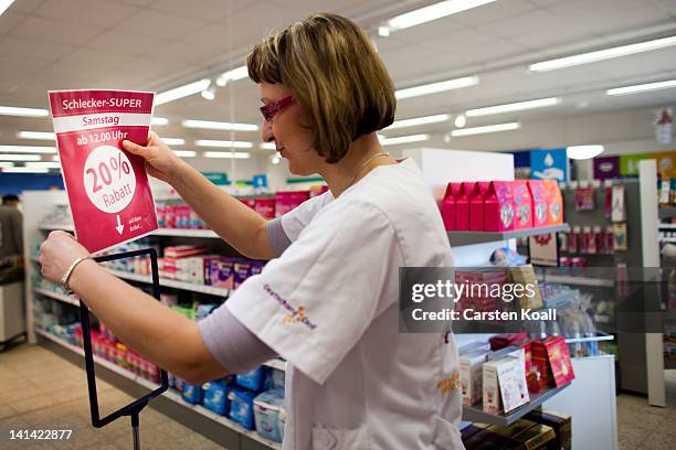 Deputy branch manager Wenke Kienitz prepares a sign for special offers at a Schlecker drugstore on March 16, 2012 in Strausberg, Germany. The German...