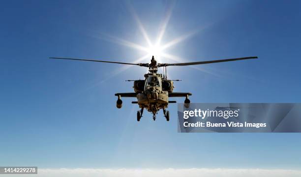flying apache helicopter at sunset - apache helikopter stockfoto's en -beelden