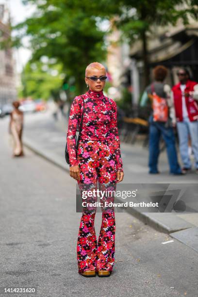 Guest wears gray cat eyes sunglasses, a red / purple / pink / white flower print pattern turtleneck / long sleeves t-shirt, matching red / purple /...