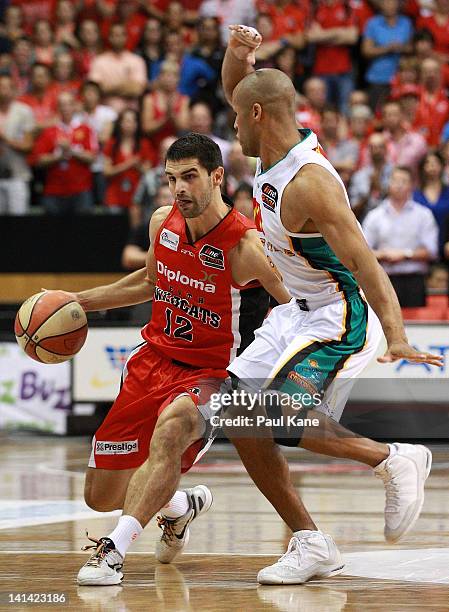 Kevin Lisch of the Wildcats looks to drive past Eddie Gill of the Crocodiles during the round 24 NBL match between the Perth Wildcats and the...