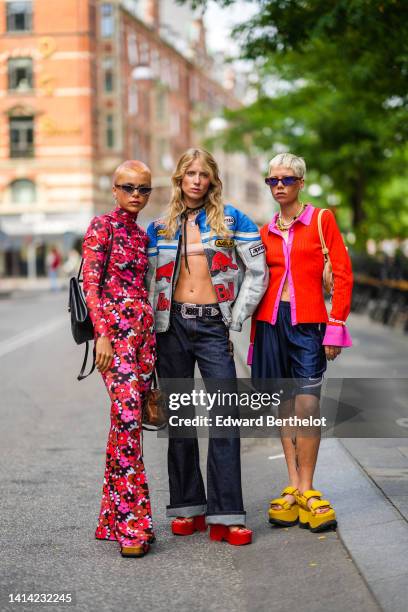 Guest wears gray cat eyes sunglasses, a red / purple / pink / white flower print pattern turtleneck / long sleeves t-shirt, matching red / purple /...