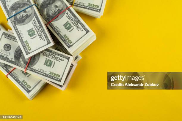 a banknote in us dollars in bundles on a bright background. the concept of finance and economics, investments. salary, bribe, profit or credit funds. space for copying. - american one hundred dollar bill stockfoto's en -beelden