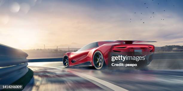 generic red electric sports car driving fast around corner on wet racetrack - muscle car imagens e fotografias de stock