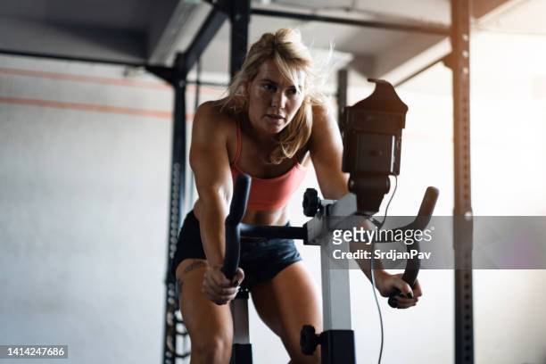 active sportswoman, exercising on the stationary cycling machine - spin class stock pictures, royalty-free photos & images