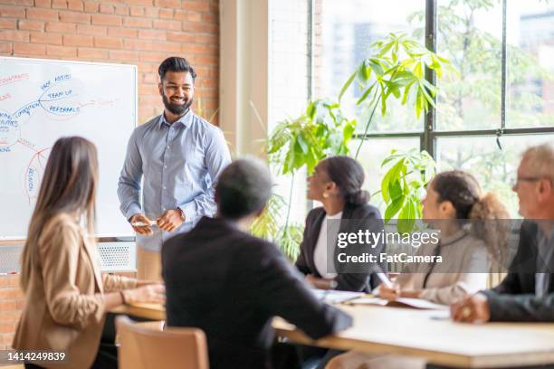 gentleman leading a business meeting - company director stock pictures, royalty-free photos & images